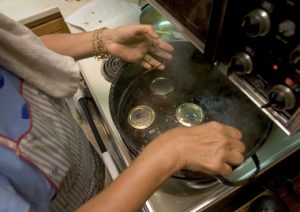 20050908CGB 6/X Mary Ann Brahler lowers a rack of jars, just filled with tomato sauce, into a pot of boiling water to get the lids to seal on with a vaccuum while canning the last of her tomatoes. 9/8/2005 CHRISTOPHER BARTH/FOR THE STAR-LEDGER